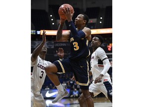 Drexel's Troy Harper (3) goes up for a basket while guarded by Connecticut's Alterique Gilbert (3) and Tarin Smith (2) during the first half of an NCAA college basketball game, Tuesday, Dec. 18, 2018, in Hartford, Conn.