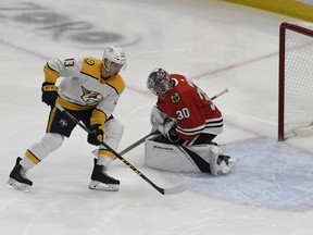 Chicago Blackhawks goaltender Cam Ward (30) makes a save on Nashville Predators center Nick Bonino (13) during the first period of an NHL hockey game Tuesday, Dec. 18, 2018, in Chicago.