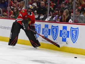 Chicago Blackhawks goaltender Corey Crawford (50) passes the puck during the first period of an NHL hockey game against the San Jose Sharks Sunday Dec. 16, 2018, in Chicago. Crawford left the game with 1:30 left in the first period after the back of his head struck the right post during a goalmouth pile-up.