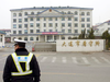 A police officer stands outside a prison in Dalian in China’s Liaoning Province.