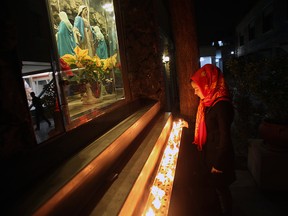 An Iranian girl lights a candle at Saint Mary Chaldean-Assyrian Catholic Church, in downtown Tehran, in a file photo from Christmas Eve 2012.