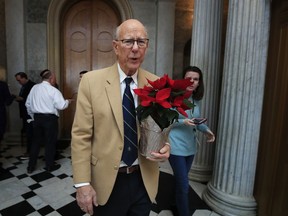Sen. Pat Roberts, R-Kan., carries a poinsettia on Capitol Hill in Washington, Monday, Dec. 24, 2018, after a pro forma session, a brief meeting of the Senate, during a partial government shutdown. Both sides in the long-running fight over funding President Donald Trump's U.S.-Mexico border wall appear to have moved toward each other, but a shutdown of one-fourth of the federal government entered Christmas without a clear resolution in sight.