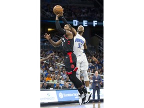 Toronto Raptors forward CJ Miles (0) shoots while Orlando Magic guard Terrence Ross (31) tries to block the shot during the first half of an NBA basketball game in Orlando, Fla., Friday, Dec. 28, 2018.