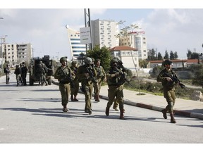 Israeli soldiers conduct a search for suspects of a shooting attack yesterday in the West Bank City of Ramallah, Monday, Dec. 10, 2018. Israeli officials say seven people have been wounded, one critically, in a shooting by a suspected Palestinian assailant outside a Jewish settlement of Ofra in the West Bank.