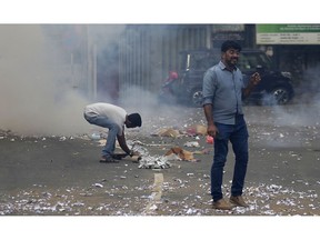 Supporters of ousted Sri Lankan Prime Minister Ranil Wickremesinghe light firecrackers outside the supreme court complex in Colombo, Sri Lanka, Thursday, Dec. 13, 2018.  Sri Lanka's Supreme Court unanimously ruled as unconstitutional President Maithripala Sirisena's order to dissolve Parliament and call for fresh elections, a much-anticipated verdict Thursday that further embroils the Indian Ocean island nation in political crisis.