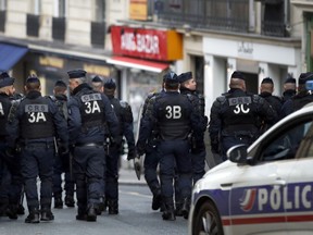 Policemen stand guard during a demonstration of students in Paris, Tuesday, Dec. 18, 2018. France's interior minister is to meet with representatives of police unions, following complaints about working conditions and calls for a work slowdown over what unions say are strained resources after five straight weekends of sometimes violent protests.