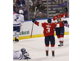 Florida Panthers center Aleksander Barkov, right, celebrates with defenseman Keith Yandle, center, after shooting and scoring against Toronto Maple Leafs goaltender Frederik Andersen, left, during the first period of an NHL hockey game on Saturday, Dec. 15, 2018, in Sunrise, Fla.