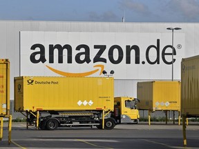 FILE - In this file photo dated Wednesday, Nov. 14, 2018, post trucks leave the Amazon Logistic Center in Rheinberg, Germany. Workers at two Amazon distribution centers in Germany have gone on strike as part of a push for improved work conditions, leading to fears that Christmas orders may not arrive in time. The German news agency dpa reported that workers in Leipzig in eastern Germany and Werne in western Germany went on strike early Monday.