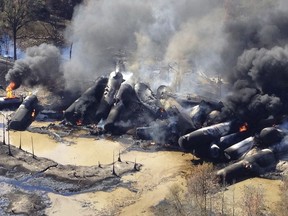 FILE- In this Nov. 8, 2013 file photo, a tanker train carrying crude oil burns after derailing in western Alabama outside Aliceville, Ala. The Trump administration vastly understated the potential benefits of installing more advanced brakes on trains that haul explosive fuels when it cancelled a requirement for railroads to begin using the equipment. A government analysis used by the administration to justify the cancellation omitted up to $117 million in potential reduced damages from using electronic brakes. Department of Transportation officials acknowledged the error after it was discovered by The Associated Press during a review of federal documents but said it would not have changed their decision.