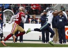 Seattle Seahawks wide receiver Tyler Lockett, right, catches a pass in front of San Francisco 49ers cornerback D.J. Reed Jr. (32) during the first half of an NFL football game in Santa Clara, Calif., Sunday, Dec. 16, 2018.