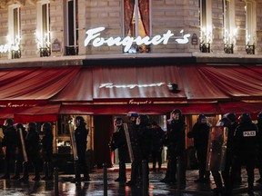 Riot police officers take position on the Champs Elysees Avenue as the famous restaurant 'Fouquet's' is seen in the background during a yellow vests demonstration in Paris.