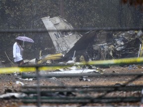 A person investigates the scene of a small plane crash in a city park which killed all on board, Thursday, Dec. 20, 2018, in northwest Atlanta.