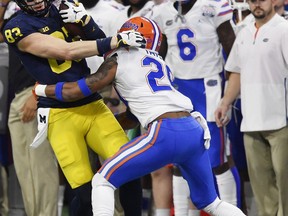 Florida defensive back Jeawon Taylor (29) tackles Michigan tight end Zach Gentry (83) during the first half of the Peach Bowl NCAA college football game, Saturday, Dec. 29, 2018, in Atlanta.