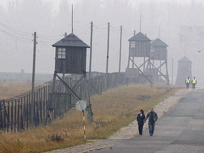A couple walks along the outer fence of the former Nazi death camp Majdanek outside Lublin in eastern Poland on Nov. 9, 2005.