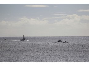 A U.S. Coast Guard vessel and other rescue boats respond to a plane crash off Honolulu, Wednesday, Dec. 12, 2018. Federal Aviation Administration spokesman Ian Gregor said a Hawker Hunter jet went down in the ocean around 2:25 p.m. after taking off from Honolulu's airport. A civilian contractor for the Hawaii Air National Guard who was participating in a military exercise survived after his plane crashed off the coast of Honolulu, authorities said Wednesday. U.S. Coast Guard spokeswoman Petty Officer Sara Muir said the pilot is in stable condition after being rescued about 3 miles south of Oahu near Honolulu's Sand Island.