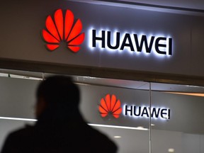 A man walks past a Huawei store in Beijing on December 10, 2018.