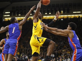 Iowa forward Tyler Cook, center, drives to the basket over Savannah State's Zaquavian Smith, left, and Romani Hansen, right, during the first half of an NCAA college basketball game, Saturday, Dec. 22, 2018, in Iowa City, Iowa.