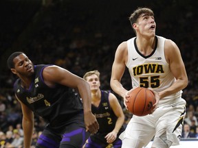 Iowa forward Luka Garza (55) drives to the basket ahead of Western Carolina forward Carlos Dotson, left, during the first half of an NCAA college basketball game, Tuesday, Dec. 18, 2018, in Iowa City, Iowa.