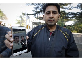 FILE - In this Sept. 26, 2018 file photo, Pakistani businessman Mirza Imran Baig shows a picture with his Uighur wife, Malika Mamiti, outside the Pakistani embassy in Beijing, China. Mamiti, was sent to a political indoctrination camp after returning to China's far west Xinjiang region in May 2017, Baig said. Scores of Pakistani men whose Muslim Uighur wives have disappeared into internment camps in China feel helpless, fighting a wall of silence as they struggle to reunite their families.