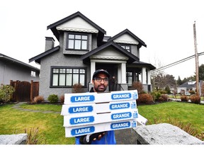 A pizza delivery man delivers pizza to the media after being instructed to do so by people inside of Huawei chief financial officer Meng Wanzhou's home in Vancouver on Wednesday, December 12, 2018.