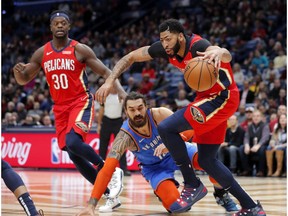 New Orleans Pelicans forward Anthony Davis (23) battles for control of the ball against Oklahoma City Thunder center Steven Adams (12) in the first half of an NBA basketball game in New Orleans, Wednesday, Dec. 12, 2018.