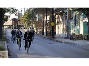 FILE - In this Feb. 13, 2015 file photo, cyclists ride along Chartres St. near the Mississippi River waterfront in the Bywater section of New Orleans. A New Orleans City Council member has released a long-awaited proposal that would ban short-term rentals of whole houses in the city's residential areas. Thursday's move by Kristen Gisleson Palmer drew an immediate rebuke from a spokesman from HomeAway, one of the businesses that arranges short-term vacation rentals online.