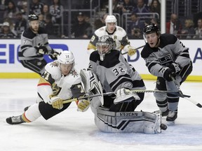 Los Angeles Kings goaltender Jonathan Quick, center, deflects a shot in front of Vegas Golden Knights' William Karlsson, left, during the first period of an NHL hockey game Saturday, Dec. 29, 2018, in Los Angeles.