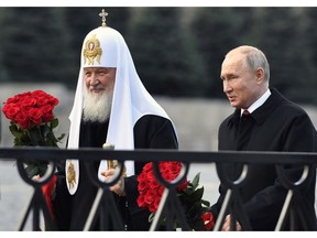 FILE - In this file photo from Nov. 4, 2018, Russian President Vladimir Putin and Russian Orthodox Church Patriarch Kirill, left, walk to lay flowers at the monument of Minin and Pozharsky at Red Square in Moscow, during National Unity Day. The Russian Church said on Friday, Dec. 14, 2018, that Patriarch Kirill has sent a letter to the U.N. secretary-general, German Chancellor Angela Merkel, French President Emmanuel Macron, Pope Francis, the Archbishop of Canterbury and other spiritual leaders, urging them to help protect the clerics, believers and their faith in Ukraine.