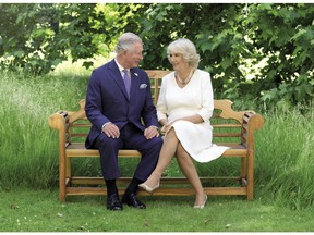 This photo released by Clarence House on Friday Dec. 14, 2018, shows the photo taken by Hugo Burnand of Britain's Prince Charles and Camilla, Duchess of Cornwall in the grounds of Clarence House, London, which is to be used as their 2018 Christmas card.