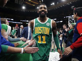 Boston Celtics' Kyrie Irving walks off the court after the Celtics defeated the Philadelphia 76ers 121-114  in overtime during an NBA basketball game in Boston, Tuesday, Dec. 25, 2018.