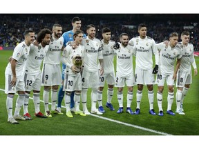 Real Madrid's Luka Modric holds his Ballon d'Or (Golden Ball) award as European Footballer of the Year as he poses with his teammates prior of he Spanish La Liga soccer match between Real Madrid and Rayo Vallecano at the Bernabeu stadium in Madrid, Spain, Saturday, Dec. 15, 2018.