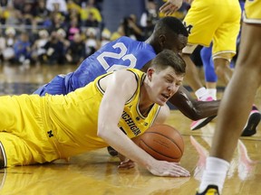 Air Force Falcons guard Pervis Louder (22) and Michigan Wolverines center Jon Teske (15) chase the loose ball during the first half of an NCAA college basketball game, Saturday, Dec. 22, 2018, in Ann Arbor, Mich.