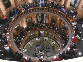 A group of school children visiting the Capitol lie on the floor of the Rotunda while demonstrators make noise and chant as Tthe Michigan Senate and House of Representatives consider bills during a "lame duck" session in Lansing, Mich., Wednesday, Dec 12, 2019. Michigan Republicans moved Wednesday to curtail ballot initiatives by advancing a measure limiting how many signatures could come from any one region of the state, the latest proposal assailed by critics as an unconstitutional, lame-duck power grab from incoming Democratic officeholders or voters.
