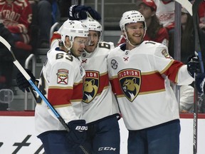 Florida Panthers' Mike Hoffman (68), center, is congratulated by right wing Evgenii Dadonov (63) of Russia and left wing Jonathan Huberdeau (11) after scoring a goal against the Detroit Red Wings during the first period of an NHL hockey game in Detroit, Saturday, Dec. 22, 2018.