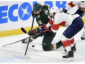 Minnesota Wild's Eric Staal (12) and Florida Panthers' Aaron Ekblad go after the puck during the first period of an NHL hockey game Thursday, Dec. 13, 2018, in St. Paul, Minn.