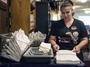 In this Tuesday, Dec. 18, 2018 photo, Shawna Green, waitress at Granny Shaffer's, prepares utensils for customers at the restaurant in Joplin, Mo. Wages will be increasing for millions of low-income workers across the U.S. as the new year ushers in new laws in numerous states. In Missouri and Arkansas, minimum wages are rising as a result of voter-approved ballot initiatives.