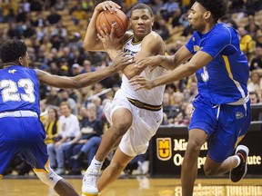 Missouri 's Javon Pickett, center, drives between Morehead State's Malik Riddle, left, and James Baker, right, during the first half of an NCAA college basketball game Saturday, Dec. 29, 2018, in Columbia, Mo.