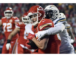 Kansas City Chiefs tight end Travis Kelce (87) is tackled by Los Angeles Chargers linebacker Jatavis Brown (57) during the first half of an NFL football game in Kansas City, Mo., Thursday, Dec. 13, 2018.