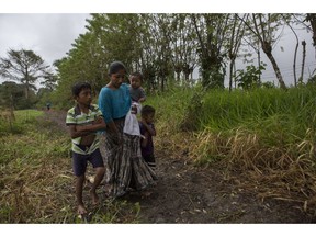 Claudia Maquin, 27, walks home with her three children, Abdel Johnatan Domingo Caal Maquin, 9, left, Angela Surely Mariela Caal Maquin, 6 months, middle, and Elvis Radamel Aquiles Caal Maquin, 5, right, in Raxruha, Guatemala, on Saturday, Dec. 15, 2018. Claudia Maquin's daughter, 7-year old Jakelin Amei Rosmery Caal, died in a Texas hospital, two days after being taken into custody by border patrol agents in a remote stretch of New Mexico desert.