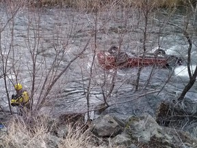 In this photo taken Wednesday, Dec. 12, 2018, provided by Cal Fire, the Siskiyou County Sheriff's dive team works at the scene where a man survived for hours trapped in his upside-down car after it plunged into a frigid river, near Yreka, Calif.