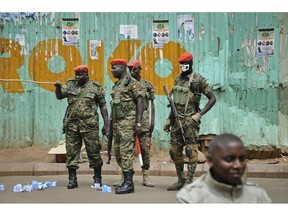 FILE - In this Thursday, Aug. 23, 2018 file photo, Ugandan military police, one wearing a balaclava with a skull painted on, patrol where supporters of pop star-turned-lawmaker Kyagulanyi Ssentamu, also known as Bobi Wine gather, in the Kisekka Market area of Kampala, Uganda. A new movement wants to find out whether President Yoweri Museveni's tentative embrace of a so-called "national dialogue", after a government showdown with opposition pop star Bobi Wine, can lead to one of Africa's longest-serving leaders being talked into giving up power.