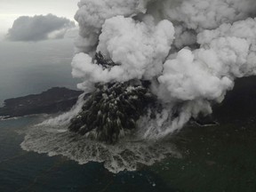 Plumes rise from Mount Anak Krakatau as it erupts in the Java Strait, Indonesia on Sunday, Dec. 23, 2018. A deadly tsunami followed an eruption and apparent undersea landslide on the volcano, gushing ashore without warning during a busy holiday weekend.