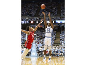 North Carolina's Kenny Williams, right, attempts a shot over Davidson's Carter Collins, left, during the first half of an NCAA college basketball game in Chapel Hill, N.C., Saturday, Dec. 29, 2018.