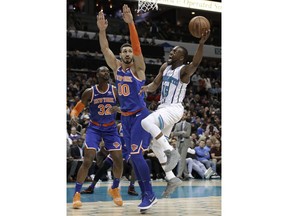 Charlotte Hornets' Kemba Walker (15) drives against New York Knicks' Enes Kanter (00) and Noah Vonleh (32) in the first half of an NBA basketball game in Charlotte, N.C., Friday, Dec. 14, 2018.