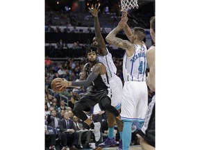 Brooklyn Nets' D'Angelo Russell (1) drives between Charlotte Hornets' Willy Hernangomez (41) and Marvin Williams during the first half of an NBA basketball game in Charlotte, N.C., Friday, Dec. 28, 2018.