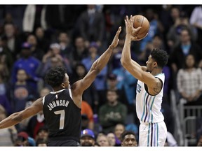 Charlotte Hornets' Jeremy Lamb, right, shoots his go-ahead and eventual game-winning basket over Detroit Pistons' Stanley Johnson (7) during the second half of an NBA basketball game in Charlotte, N.C., Wednesday, Dec. 12, 2018.