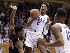 Duke's Cam Reddish (2) grabs the ball over Princeton's Richmond Aririguzoh (34) as Duke's Javin DeLaurier (12) watches at right during the first half of an NCAA college basketball game in Durham, N.C., Tuesday, Dec. 18, 2018.