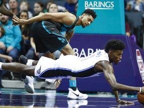 Orlando Magic forward Jonathan Isaac, right, dives for the ball while being covered by Charlotte Hornets guard Jeremy Lamb in the first half of an NBA basketball game Monday, Dec. 31, 2018, in Charlotte, N.C.