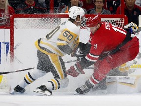 Carolina Hurricanes' Jordan Staal (11) crashes into Pittsburgh Penguins' Juuso Riikola (50) and goaltender Matt Murray (30) during the first period of an NHL hockey game, Saturday, Dec. 22, 2018, in Raleigh, N.C.