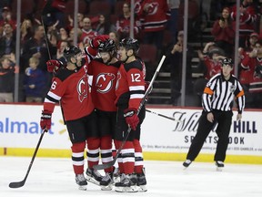 New Jersey Devils center Pavel Zacha, center, of the Czech Republic, celebrates his first-period goal against the Ottawa Senators with Andy Greene (6) and Ben Lovejoy (12) during an NHL hockey game Friday, Dec. 21, 2018, in Newark, N.J.